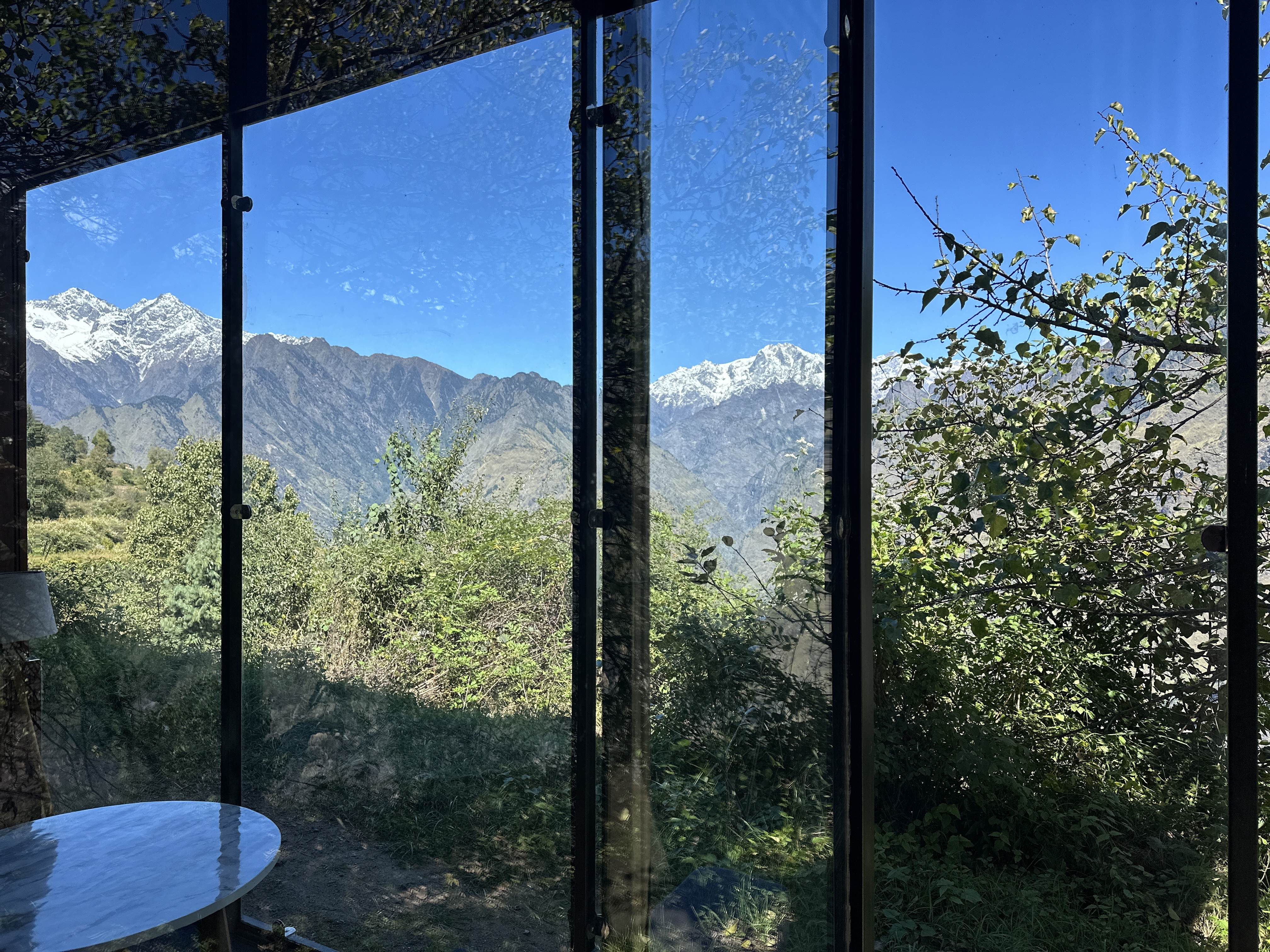 Glass Cabin exterior framing the Himalayan peaks in Auli